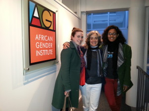 three women pose in front of African Gender Institute sign