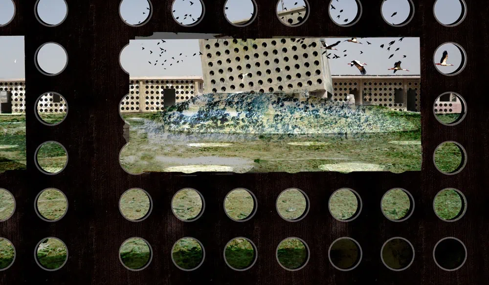Close-up of perforated concrete installation with scenic view behind, highlighting architecture and design.