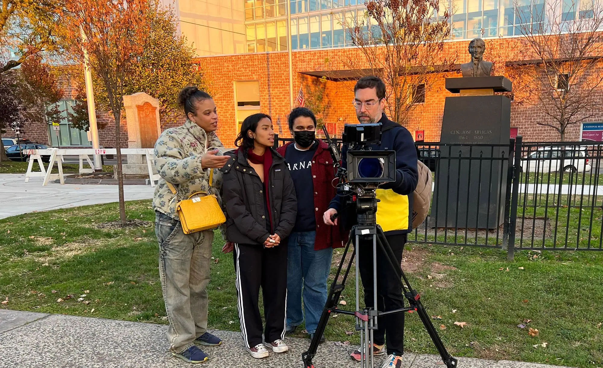 An outdoor scene featuring women discussing a project in front of Barnard Center for Research on Women, capturing a collaborative moment.