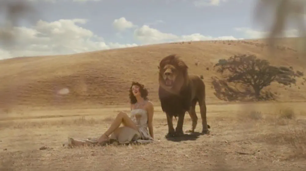 Taylor Swift Wildest Dreams Music Video still: Taylor Swift in the desert next to a lion