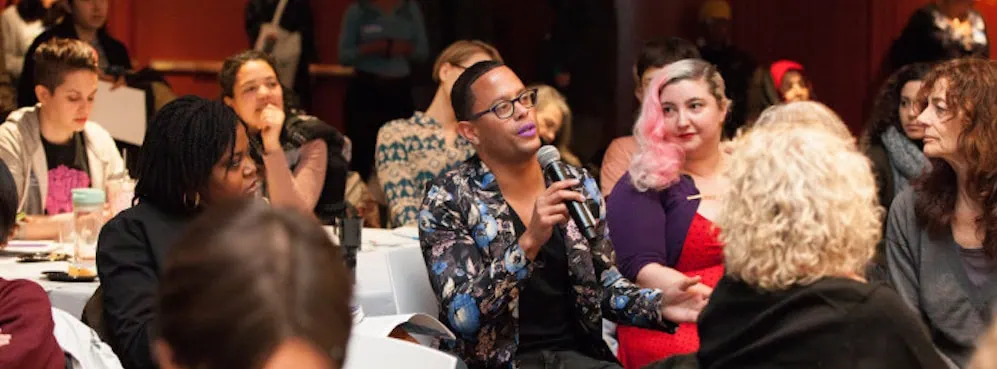 Che Gossett speaking in a crowd at Scholar and Feminist 41