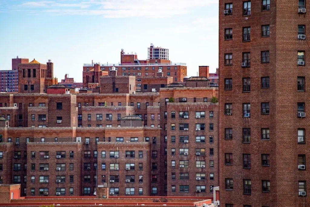 Detailed view of urban residential buildings with numerous windows and air conditioning units.