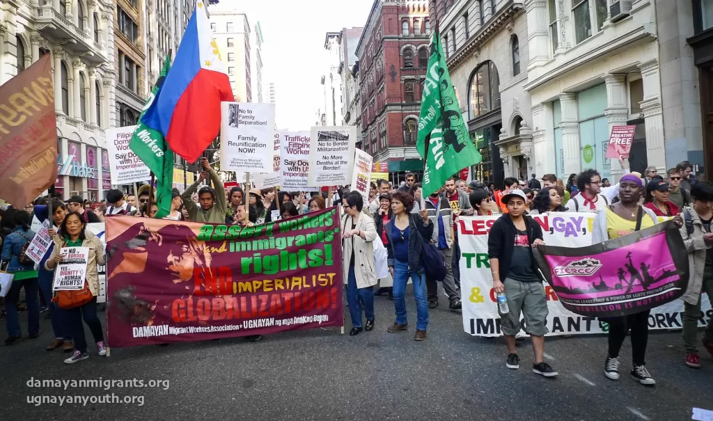 Protest march for immigrant, women's, and LGBTQ+ rights featuring diverse participants with banners and flags in urban streets.