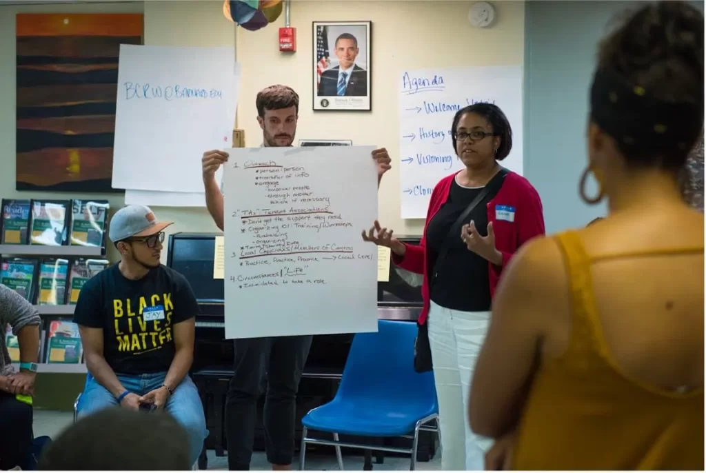 Diverse group participating in a workshop on women’s research and advocacy.
